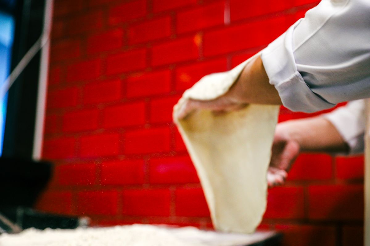 Dough being stretched by hand in the Slice and Stone kitchen