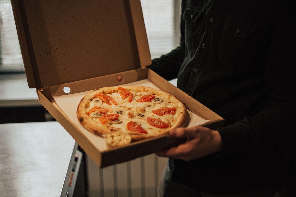 Pizza box handed over at the counter